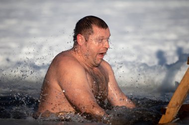İsa 'nın vaftiz töreninde bir adam buz çukuruna dalıyor. Bir adam kışın buz çukurunda yüzer. Deniz aygırları..