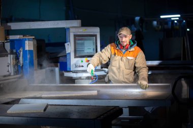 Programlanmış bir makinenin arkasında mobilya parçaları yapan bir mobilya üreticisi. Mobilya imalatı.