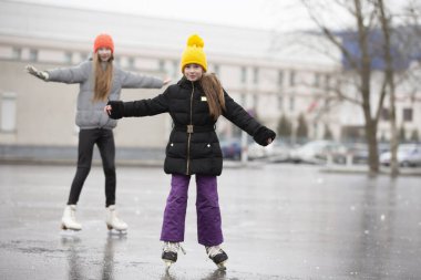 Çocuklar kışın şehir binalarının arka planında buz pateni yapmaya giderler. Kış açık hava oyunları.