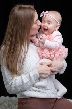 Annesi küçük kızını kollarında tutuyor. Annelik.