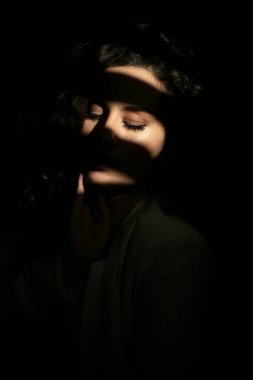 Yüzünde gölge var. Işıklı güzel bir kadın yüzü. Doğulu bir kadının gölgeli yüzü.