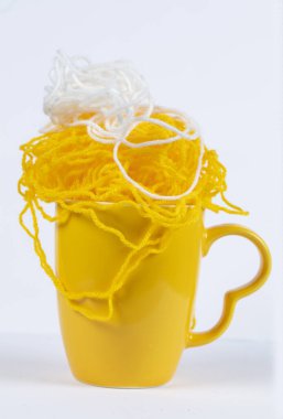 Sarı kupa ve sarı örgü iplikler..