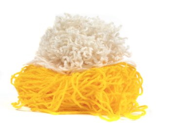 Beyaz arkaplanda örgü örmek için sarı ve beyaz iplikler.