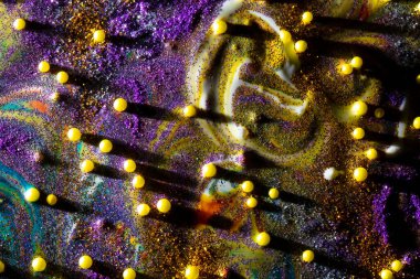 Mor ve altın kıvılcımlar serpiştirilmiş çok renkli akrilik arka plan. Çağdaş yaratıcılık. Renkli ve yenilikçi bir tablo, zengin bir dokusu var. Birçok şekil ve malzemeden oluşan bir arkaplan.