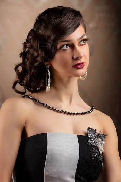 Retro woman portrait. Beautiful lady in 20s or 30s style. Old fashionable Finger Wave makeup and hairstyle.