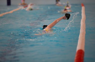 Çocuk sporcu havuzda yüzer. Yüzme bölümü.