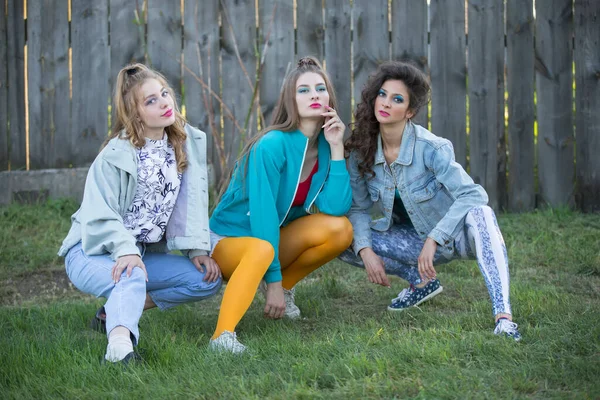Vicces Lányok Stílus Években Fényes Ruhákban Ülnek Egy Kerítés Mellett — Stock Fotó