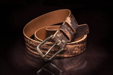 Kahverengi deri kemer, sürtünme ve siyah arka planda metal toka..