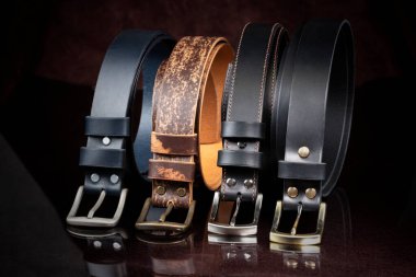 Koyu arkaplanda bir grup deri kemer.