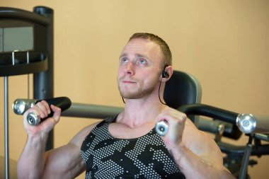 Atletik fiziği olan yakışıklı bir adam simülatörde çalışıyor..