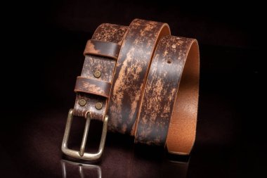 Kahverengi deri kemer, sürtünme ve siyah arka planda metal toka..