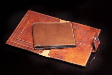 Koyu arka planda cepleri olan açık kahverengi bir çanta..