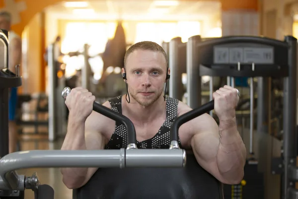 Atletik fiziği olan yakışıklı, genç ve güçlü bir adam spor simülatörüne bağlandı..