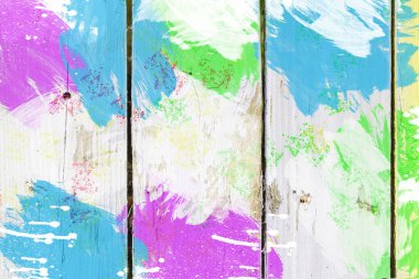 Parlak renkli boyalarla kaplı eski tahtalar. Parlak çitin neşeli ahşap arka planı.