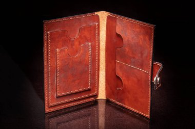 Koyu arka planda cepleri olan açık kahverengi bir çanta..