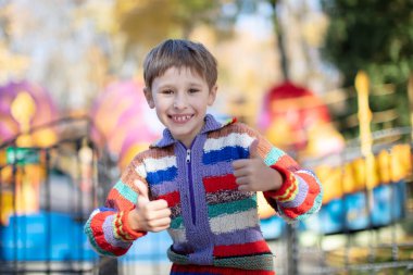 Parkın parlak arka planında mutlu küçük çocuk.