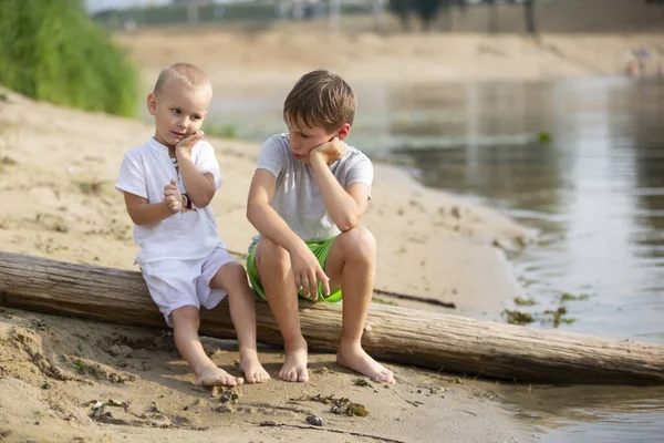 兄と弟の2人は川のそばで遊んでいる 砂浜での子供たちの話と楽しみ — ストック写真