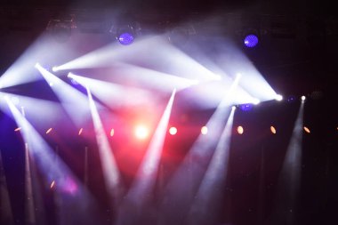 Işıklı bir sahne. Işıklar kırmızı ve mavi. Sahnede bir sürü ışık var.