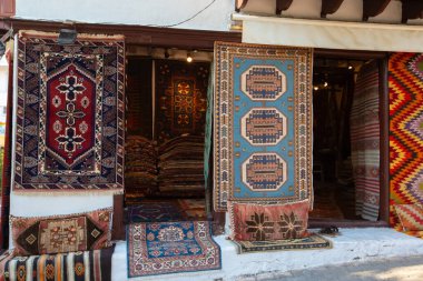 Türk halılarının çeşitli etnik renklerde olduğu küçük bir dükkan.