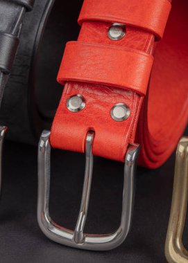 Gri arka planda metal tokalı deri kemerler..