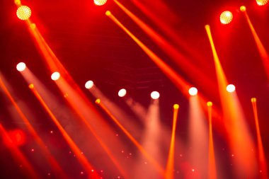 Sahne beyaz ve arka planda kırmızı ışık huzmeleri. Konser için sahne aydınlatma.
