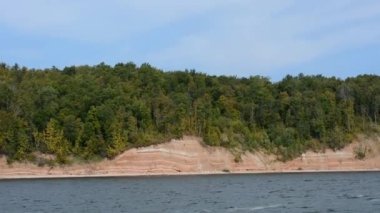 Güneşli bir günde, nehir yolcusu hidrofolyo gemisi Meteor 'un Volga nehri boyunca 342E projesiyle seyahat edin. Sonbahar manzarası. El kamerasıyla ateş edilmiş. Kamera sallaması.