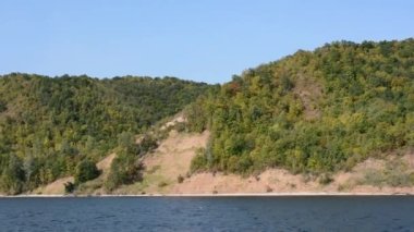 Güneşli bir günde, nehir yolcusu hidrofolyo gemisi Meteor 'un Volga nehri boyunca 342E projesiyle seyahat edin. Sonbahar manzarası. El kamerasıyla ateş edilmiş. Kamera sallaması.