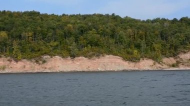 Güneşli bir günde, nehir yolcusu hidrofolyo gemisi Meteor 'un Volga nehri boyunca 342E projesiyle seyahat edin. Sonbahar manzarası. El kamerasıyla ateş edilmiş. Kamera sallaması.