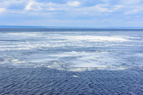 Natural ice blocks breaking up against shore during spring weather. Arctic, winter, spring landscape. Ice drift along the Volga river.