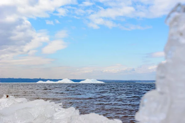 Natural ice blocks breaking up against shore during spring weather. Arctic, winter, spring landscape. Ice drift along the Volga river.