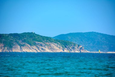 Sunny day, sand creaking, clear turquoise sea, coral reefs on the coast of Yalong Bay in South China Sea. Sanya, island Hainan, China. Nature Landscape. clipart