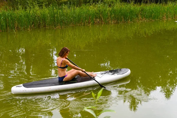 Kvinna Kör Sup Board Genom Smal Kanal Omgiven Tätt Gräs — Stockfoto