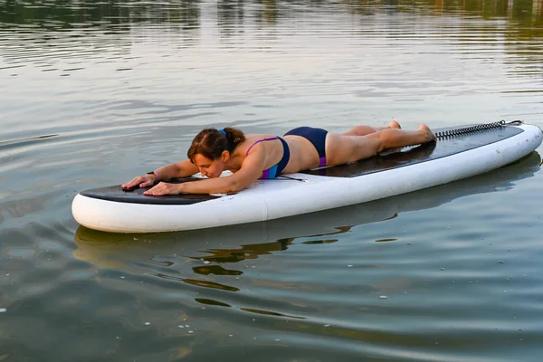 Самотня Жінка Лежить Соп Борді Оточенні Озера Під Час Заходу — стокове фото