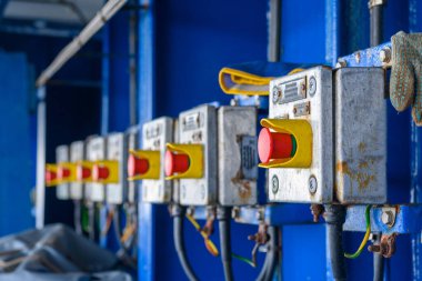 Endüstriyel kontrol düğmeleri parlak mavi bir zemin üzerinde duruyor. Bu da Rusya 'nın üretim endüstrisindeki makinelerin işlevselliğini ve önemini yansıtıyor..