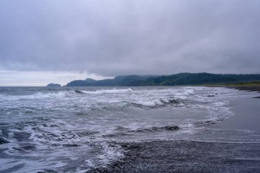 Gözlerden uzak bir Rus sahilinde dalgalar yavaşça kıyıya vurur. Üzerimizde kara bulutlar süzülüyor, kayalık kıyı şeridinde sakin bir atmosfer yaratarak, huzurlu bir tefekküre yol açıyor..