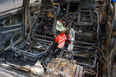 Aracın içinde yanmış kalıntılar alevlerin yol açtığı hasarı gösteriyor. Koltuklar yanmış ve kablolar ortaya çıkmış. Trajik bir olayın habercisi..