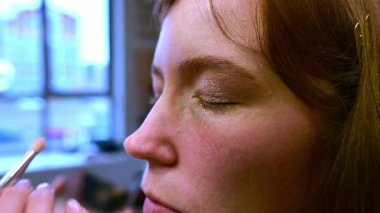 Yetenekli bir sanatçı bir Japon salonunda bir kadının doğal güzelliğini artırır. Makyajın narin uygulaması, onun güzelliğini ve zarafetini ortaya koyuyor..