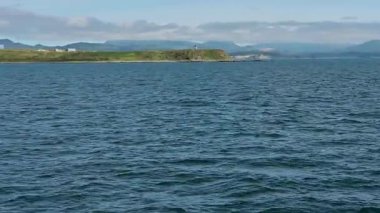 Kuril Adaları 'nın dingin güzelliğini görkemli bir yolcu gemisinin sakin mavi okyanusta yol almasını tecrübe edin. Dalgalar nazikçe tekneye doğru süzülür. Resmedilmeye değer manzaralar ortaya çıkar..