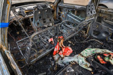Yanmış bir arabanın içi, yanmış metal ve kablolarla kaplı yangın kalıntıları gösteriyor..
