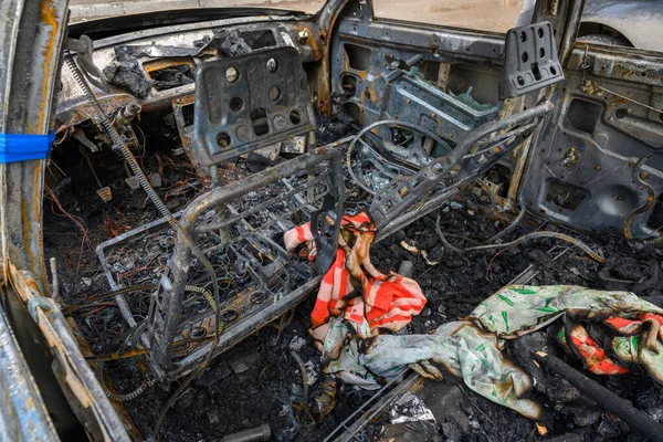 Yanmış bir arabanın içi, yanmış metal ve kablolarla kaplı yangın kalıntıları gösteriyor..