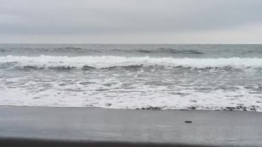 Okyanus dalgalarının rahatlatıcı ritmini Kunashir Adası 'nın yumuşak kumlu kıyılarıyla karşılaştır. Bulutlu gökyüzü rahatlama ve yansıma için mükemmel sakin bir atmosfer yaratır..