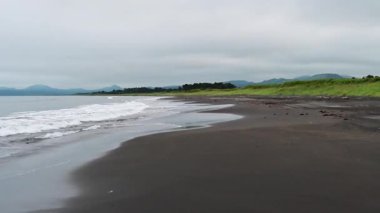 Nazik dalgalar sahili öperken Kunashir sahilinin sakin güzelliğini keşfedin. Doğanın ritmi sakin atmosferle harmanlanır, rahatlamayı ve deniz tarafından yansıtılmayı davet eder..