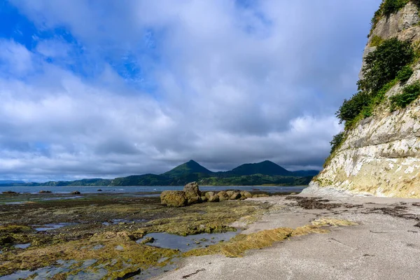 Rusya 'da sakin bir sahilin süpürücü manzaraları kayalık oluşumlar, yumuşak dalgalar ve bulutlu bir gökyüzü altında görkemli dağlar, doğada keşif ve maceralara davetiye çıkarıyor..