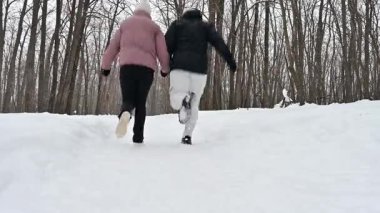 İki birey, karlı bir yolda koşarken coşkuyla el ele tutuşuyorlar. Keskin kış havası sessiz ormanı dolduruyor, karların yavaşça düştüğü yerde, büyülü bir kış harikalar diyarı yaratıyor..