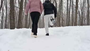 Bir çift, kış harikalar diyarında koşarken el ele tutuşuyor. Uzun ağaçlarla çevrili karlı patikalarda dolaşırken kar taneleri usulca düşer açık hava macerasına olan sevgilerini sergilerler..