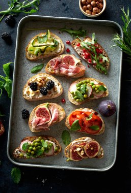 Bir set lezzetli bruschetta ve metal tepside malzemeler. Şarap için atıştırmalık parmak yemeği. Üst görünüm 