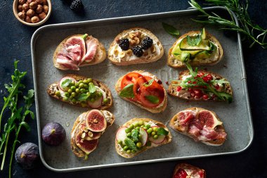 Bir set lezzetli bruschetta ve metal tepside malzemeler. Şarap için atıştırmalık parmak yemeği. Üst görünüm 