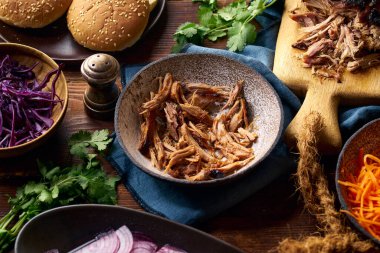 Parçalanmış domuz eti ve barbekü sosu turşulu sebzeler ve çörekler. Yavaş kavrulmuş domuz konseptiyle hamburger pişiriyorum.