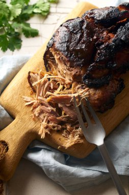 Ahşap kesme tahtasının üzerinde masa havlusuyla kaplanmış domuz eti.
