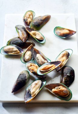 Mermer yüzeyinde çiğ kivi midyeleriyle üst görünüm